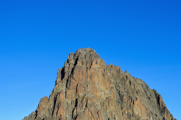 Volcanic rock formations against a blue sky at Mount Kenya