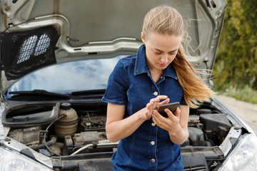 Woman with phone at broken car