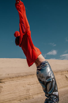 Anonymous model in strange clothes dancing under sun