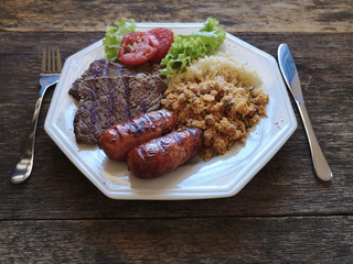 Brazilian food dish - Barbecue with beans, rice and salad.