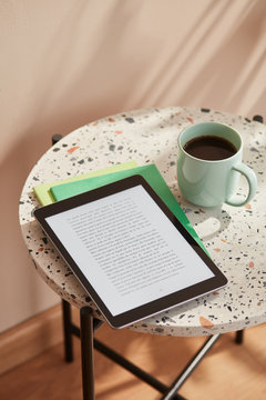 Tablet with text and cup of black coffee.