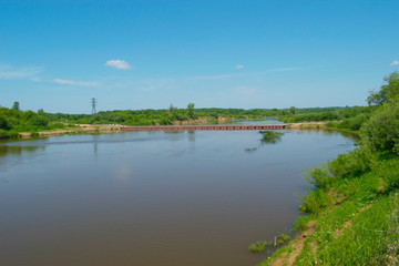 Fototapeta na wymiar A river with a pontoon bridge. Russian nature