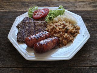 Brazilian food dish - Barbecue with beans, rice and salad.