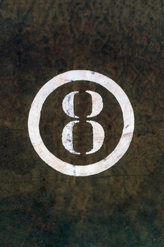 Number 8 Printed on White Over Grunge Wall