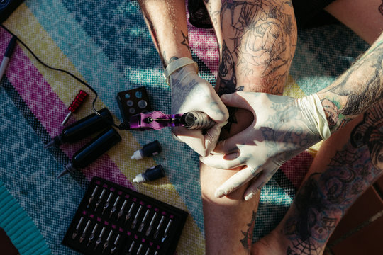 Tattoo artist tattooing himself