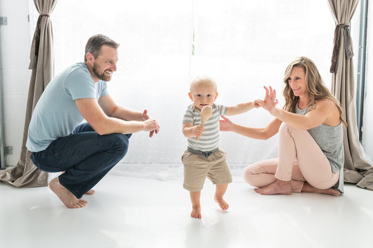 A little boy toddles around his parents