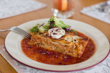 Tasty delicious italian dish lasagna with tomato sauce and cream cheese with green salat. Food, tasty dinner concept