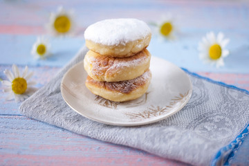 Curd cheesecakes on a white plate sprinkled with powdered sugar. Delicious dessert.