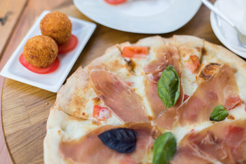 Italian pizza with jamon, basil, cheese and tomato. Food concept