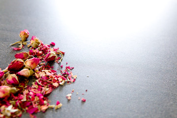 Dried red Rose bud flower  on gray / grey slate background