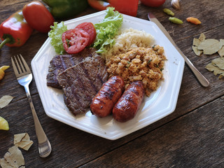 Brazilian food dish - Barbecue with beans, rice and salad.