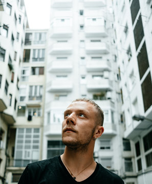 Stylish man smoking surrounded by buildings