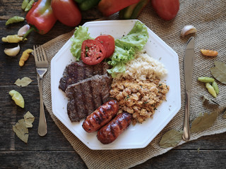 Brazilian food dish - Barbecue with beans, rice and salad.