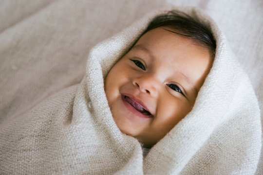 Close up of smiling baby wrapped in towel