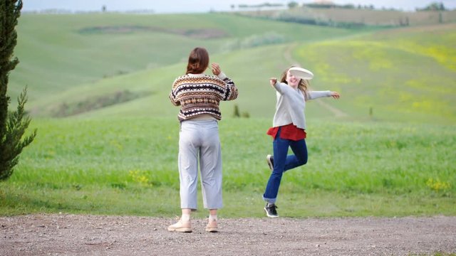 Young women playing frisbee in the summer field