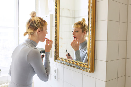 Woman applying red lipstick