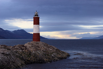 Naklejka premium Cloudy sky above a red and white lighthouse