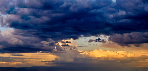 Dramatic light through the clouds against the backdrop of an exciting, bright stormy sky at sunset. panorama, natural composition