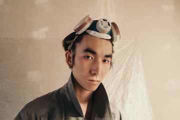 Asian guy in respirator looking at camera