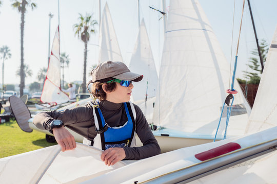 Teenage boy rigging a sail boat