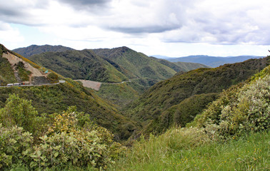 A remote valley in New Zealand. Trucks are on the road and construction vehicles are working