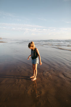 Girl enjoying the moment on the beach in a beautiful, water refl