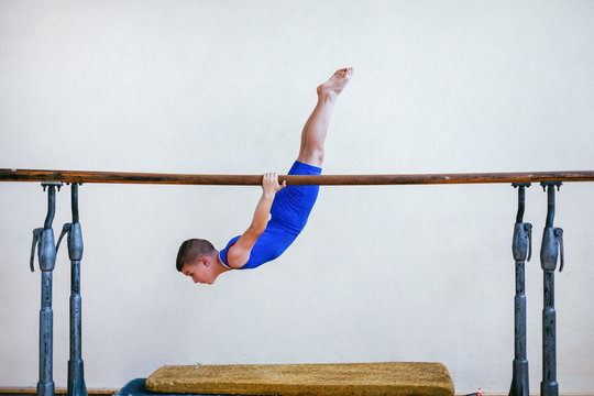 Gymnastics, young boy practicing on parallel bars