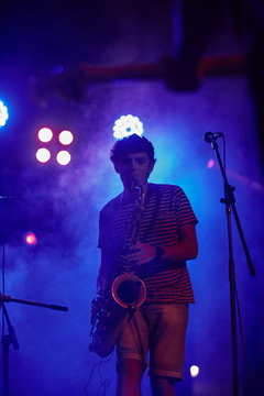 Silhouette of a musician playing the saxophone in a live concert