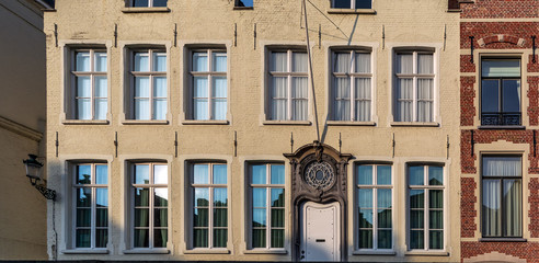 Obraz premium Exterior of medieval house facing one of the canals. Cityscape of Bruges streets shot from the boat.
