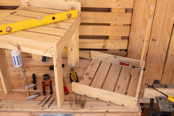 Above view of wooden table with tools to create a new chair made by recycled wood from pallet. A healthy hobby for creative people. Do it yourself and you'll appreciate