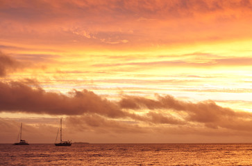 Fototapeta na wymiar A boat on the sea during a sunset after a storm in Tonga