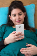 Happy Expectant Young Mom Searching on Her Smartphone