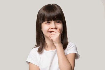 Laughing shy cute girl isolated on grey studio background