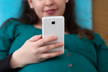 Happy Expectant Young Mom Searching on Her Smartphone