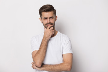 Pensive guy isolated on white background touch chin thinking