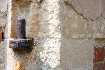 Rusty loop on the wall of an ancient temple close-up. Wall of white stone and red brick closeup.