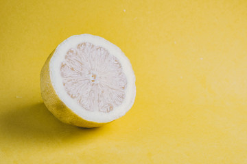 lemon cut in half on yellow background