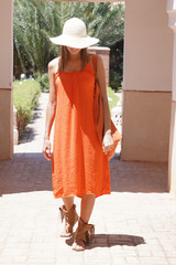 Stunning woman in bright dress exploring Moroccan riad