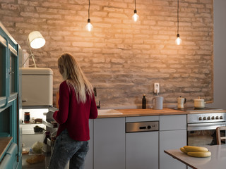 Woman opening fridge while cooking