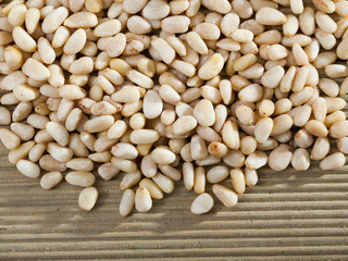 Pine nuts scattered on wooden surface
