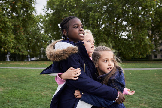 Intrigue group of friends looking away while hugging.