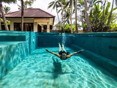 Woman swimming on the pool of a private villa in Bali
