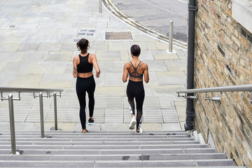 Fit female runners going downstairs for training.