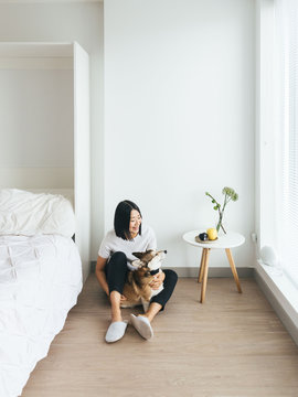 Portrait Of Girl In Minimal Apartment With Corgi Dog