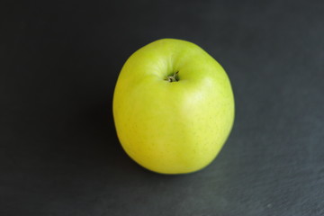 fresh raw ripe apple on black slate table background, place for text