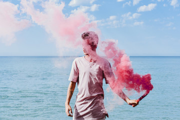 Man holding pink smoke bomb