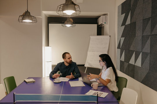 Two colleagues having a discussion while working on the computer