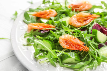 Plate with tasty shrimp salad on table, closeup