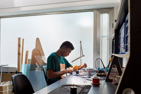 Student Working On Electrical Equipment With Tool