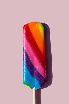 Rainbow lolly candy on a taupe background